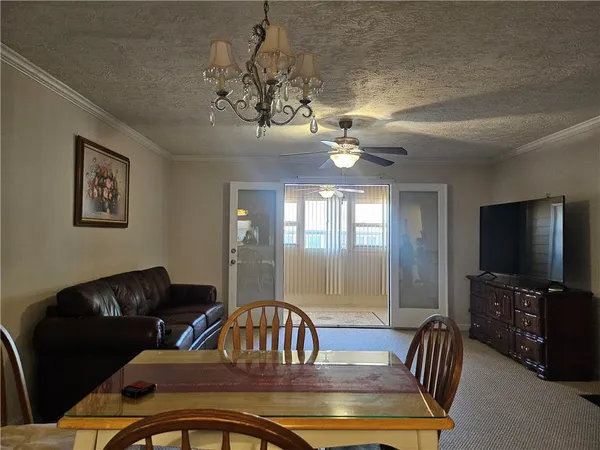 a view of a dining room with furniture a chandelier and window