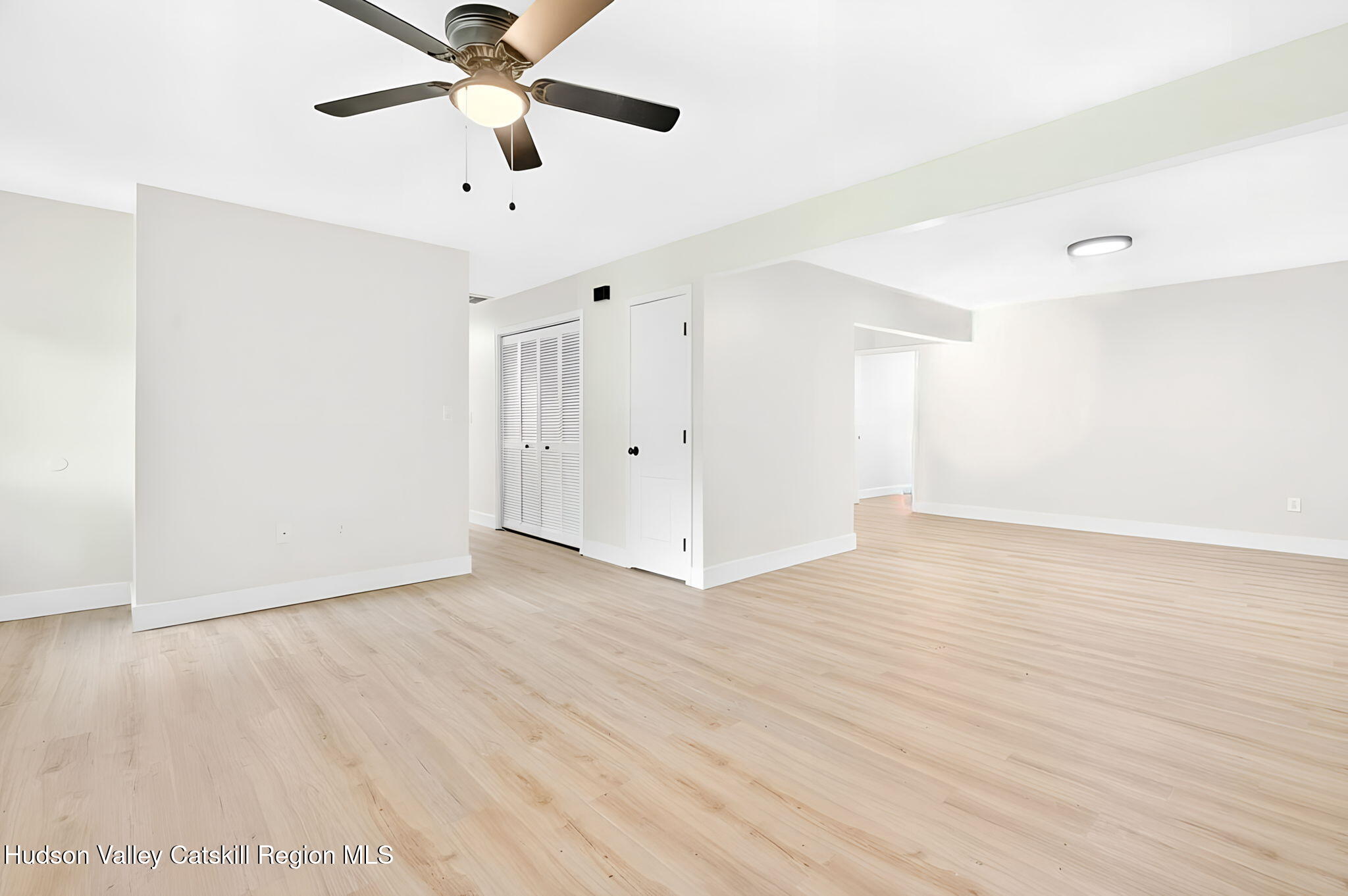 5 Lazy Brook Lane Woodstock, NY 12498 - Photo 6 of 35 a view of an empty room with window a ceiling fan and wooden floor