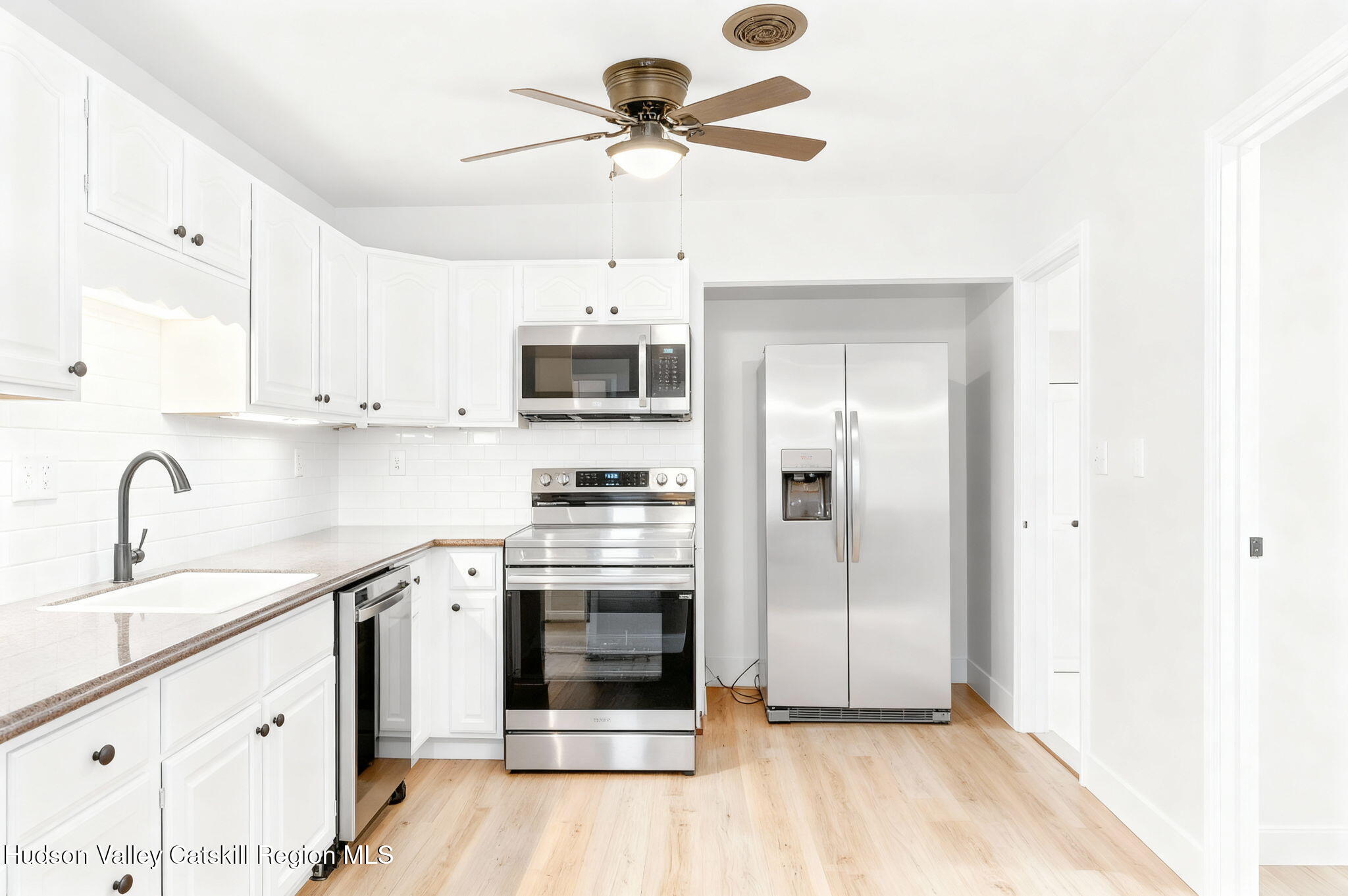 5 Lazy Brook Lane Woodstock, NY 12498 - Photo 8 of 35 a kitchen with stainless steel appliances a stove a sink dishwasher a refrigerator and white cabinets with wooden floor