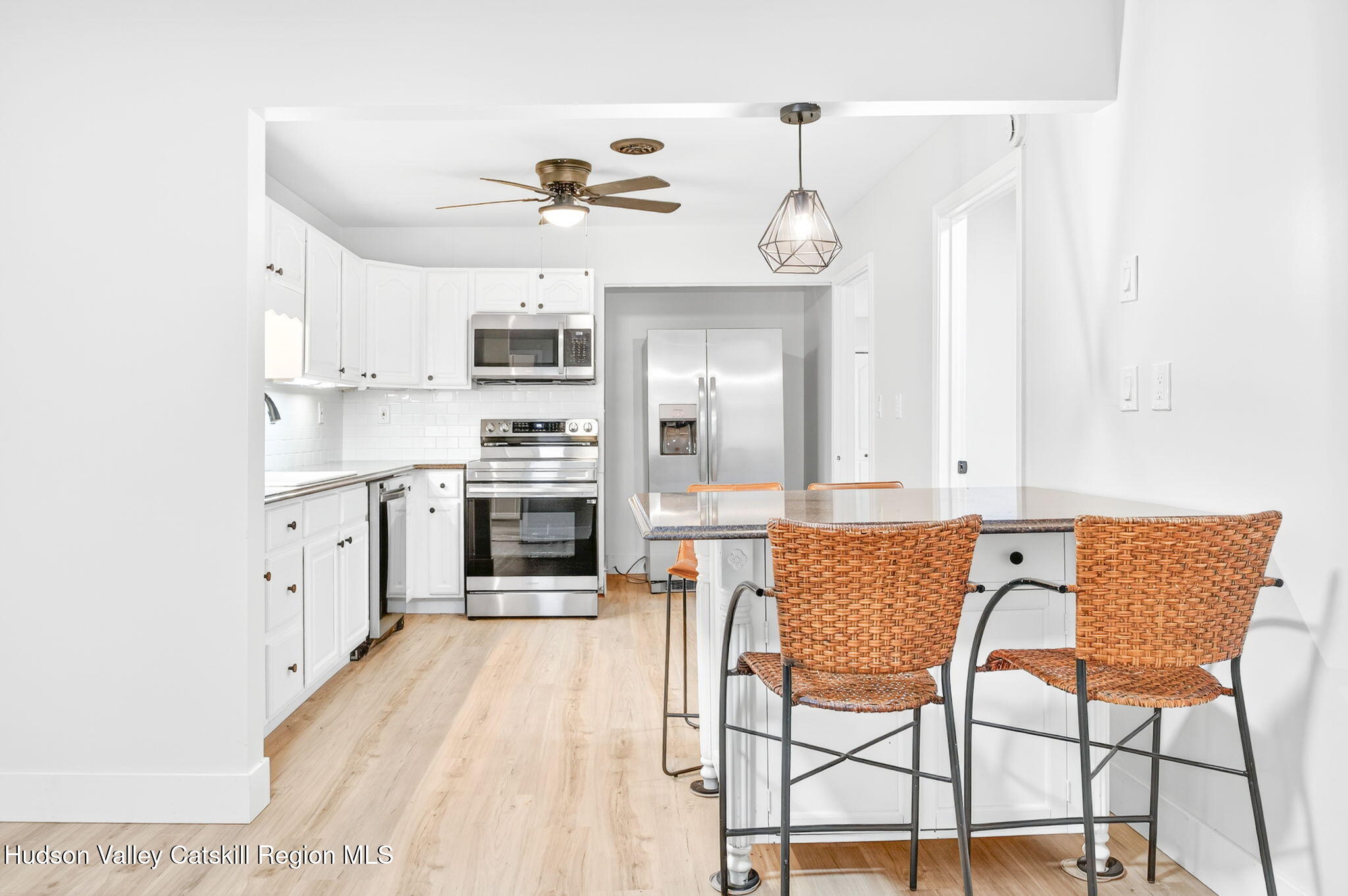 5 Lazy Brook Lane Woodstock, NY 12498 - Photo 9 of 35 a kitchen with stainless steel appliances granite countertop a stove top oven a sink dishwasher and white cabinets with wooden floor