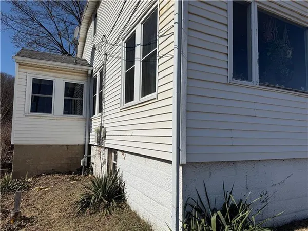 a view of a house with a door and a tree