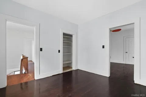 an empty room with wooden floor and closet