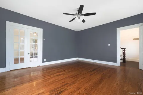 a view of a big room with wooden floor and windows