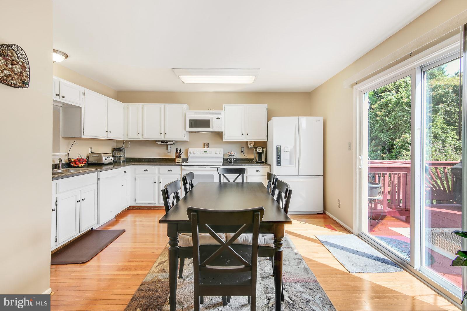 2053 Putnam Road Baltimore, MD 21227 - Photo 2 of 21 a kitchen with a dining table chairs and refrigerator