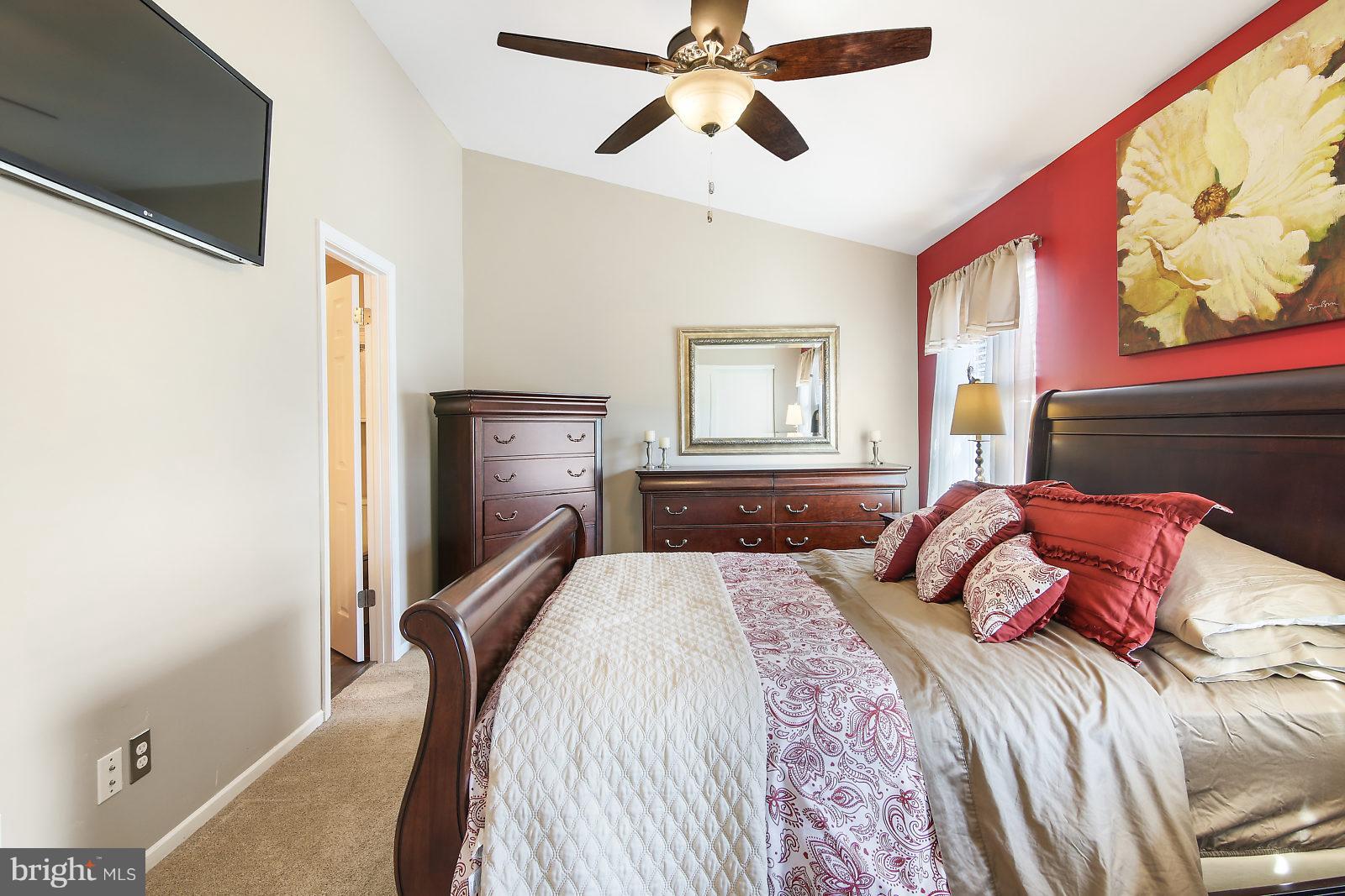 2053 Putnam Road Baltimore, MD 21227 - Photo 11 of 21 a bedroom with a bed and a chandelier