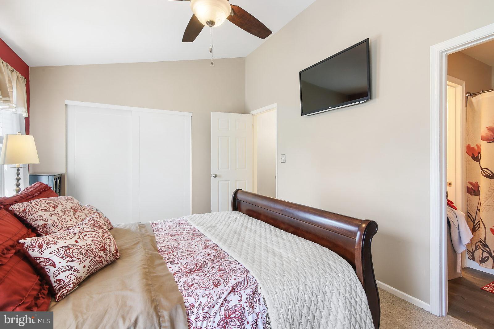 2053 Putnam Road Baltimore, MD 21227 - Photo 12 of 21 a bedroom with a large bed and a flat screen tv