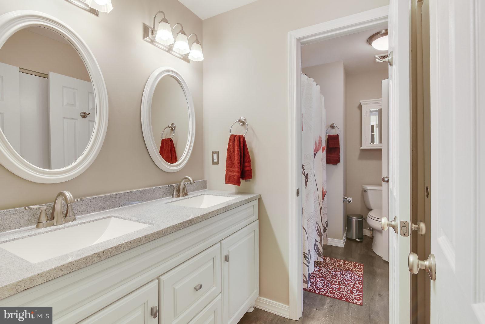 2053 Putnam Road Baltimore, MD 21227 - Photo 15 of 21 a bathroom with a double vanity sink and a mirror