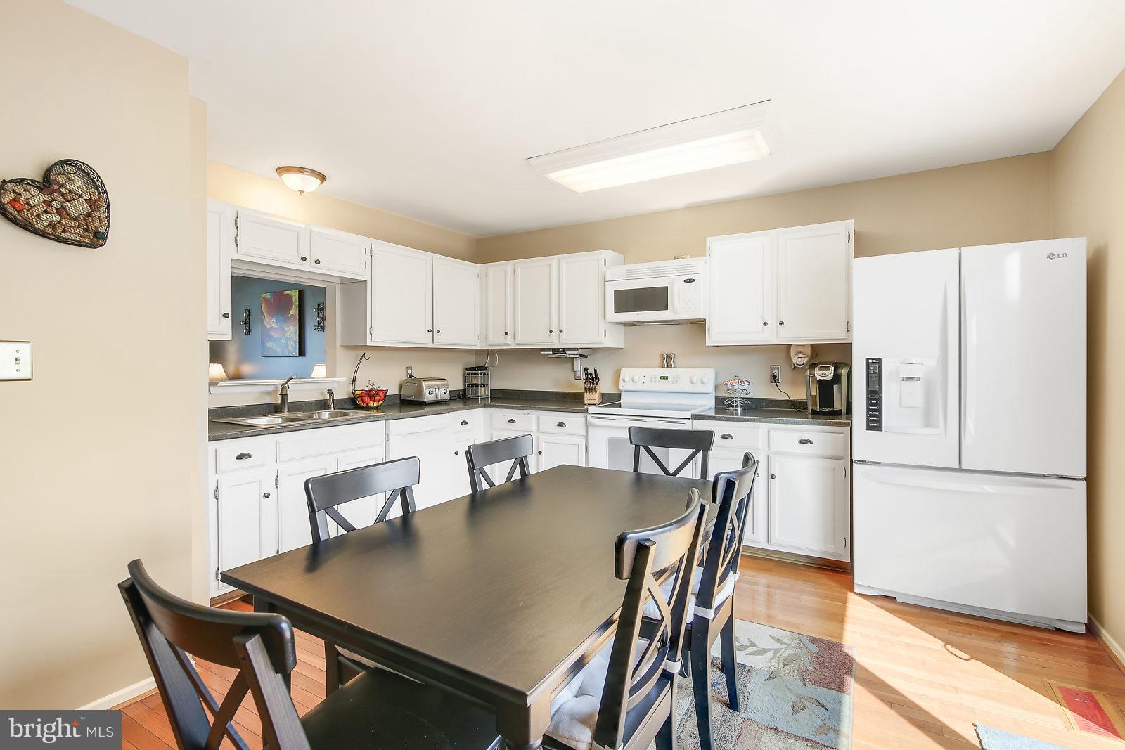 2053 Putnam Road Baltimore, MD 21227 - Photo 6 of 21 a kitchen with a dining table chairs and refrigerator