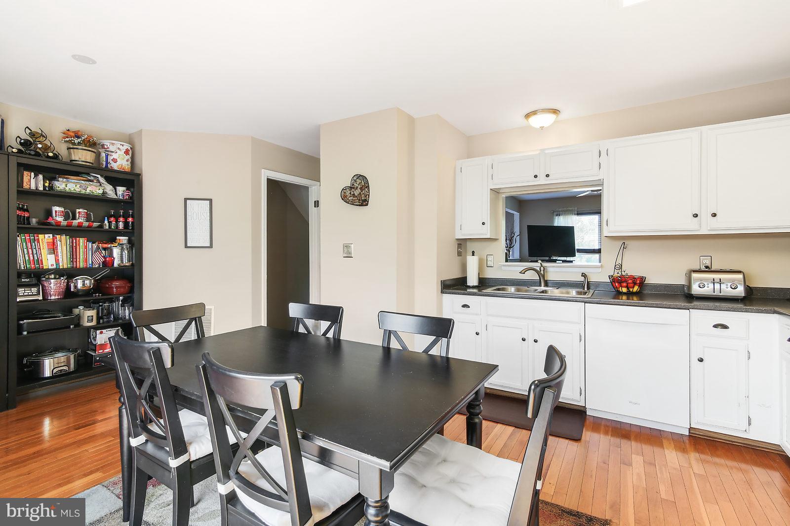 2053 Putnam Road Baltimore, MD 21227 - Photo 8 of 21 a kitchen with stainless steel appliances kitchen island granite countertop a dining table chairs and a refrigerator
