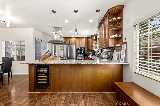 a kitchen with stainless steel appliances granite countertop a sink and wooden floors
