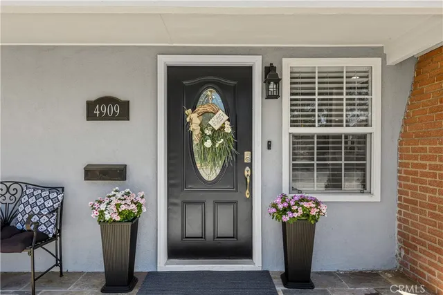 a front view of a house with outdoor seating and a potted plant