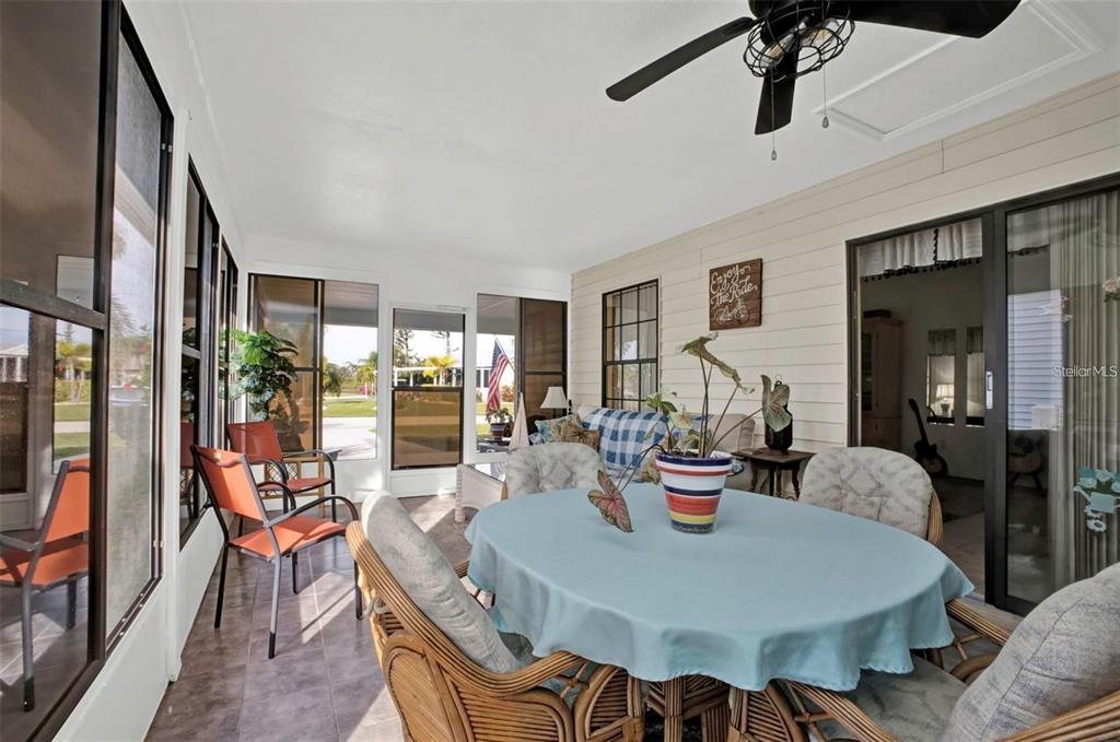 3520 Kenneth Road Port Charlotte, FL 33953 - Photo 25 of 43 a dining room with furniture a flat screen tv and a floor to ceiling window