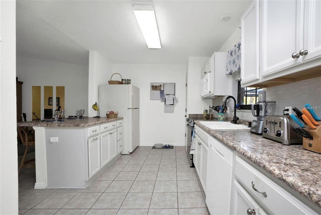 3520 Kenneth Road Port Charlotte, FL 33953 - Photo 8 of 43 a large kitchen with stainless steel appliances granite countertop a sink and cabinets