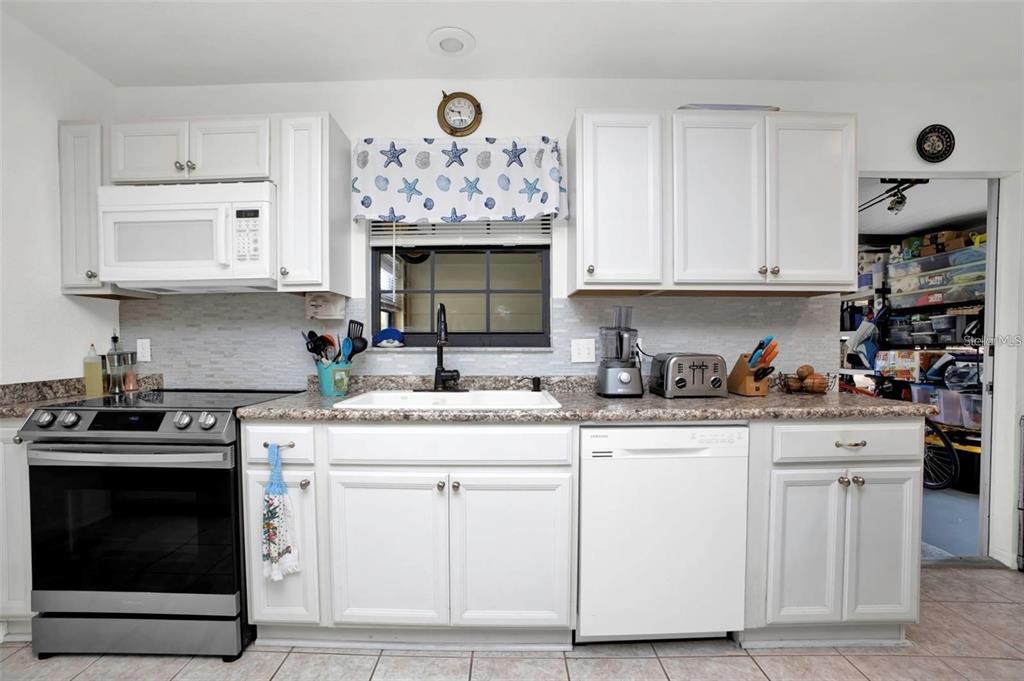 3520 Kenneth Road Port Charlotte, FL 33953 - Photo 9 of 43 a kitchen with granite countertop white cabinets and stainless steel appliances