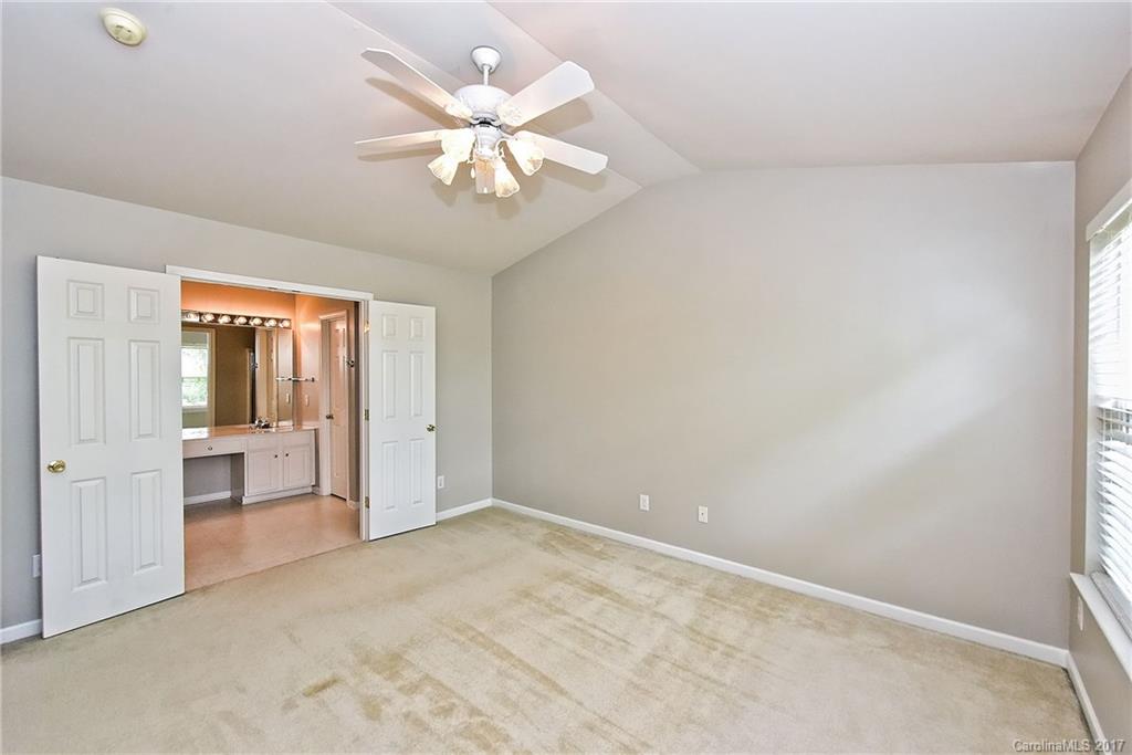 15319 McClure Bridge Road, Unit L90 Charlotte, NC 28277 - Photo 12 of 19 an empty room with chandelier fan and windows
