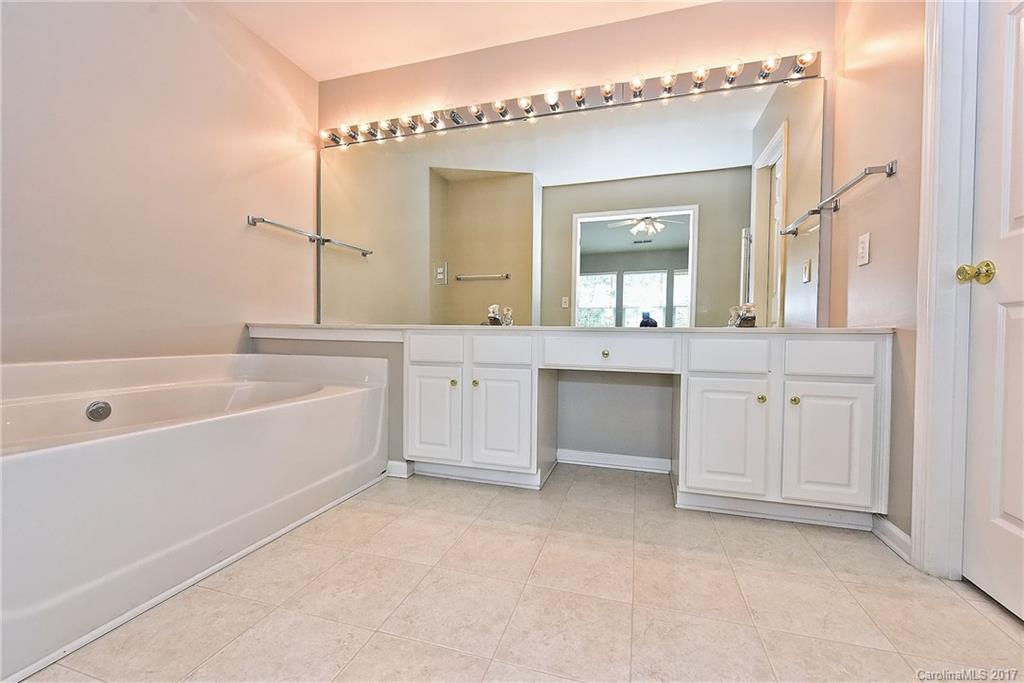 15319 McClure Bridge Road, Unit L90 Charlotte, NC 28277 - Photo 14 of 19 a spacious bathroom with a granite countertop sink a mirror and a bathtub