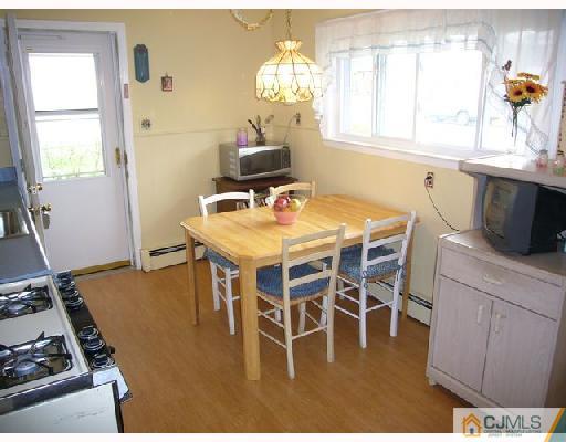 23 Kenmore Road Edison, NJ 08817 - Photo 4 of 8 a dining room with furniture a window and appliances