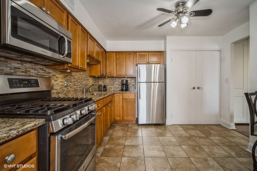 8801 West Golf Road, Unit 10E Niles, IL 60714 - Photo 11 of 21 a kitchen with stainless steel appliances granite countertop a stove microwave and refrigerator