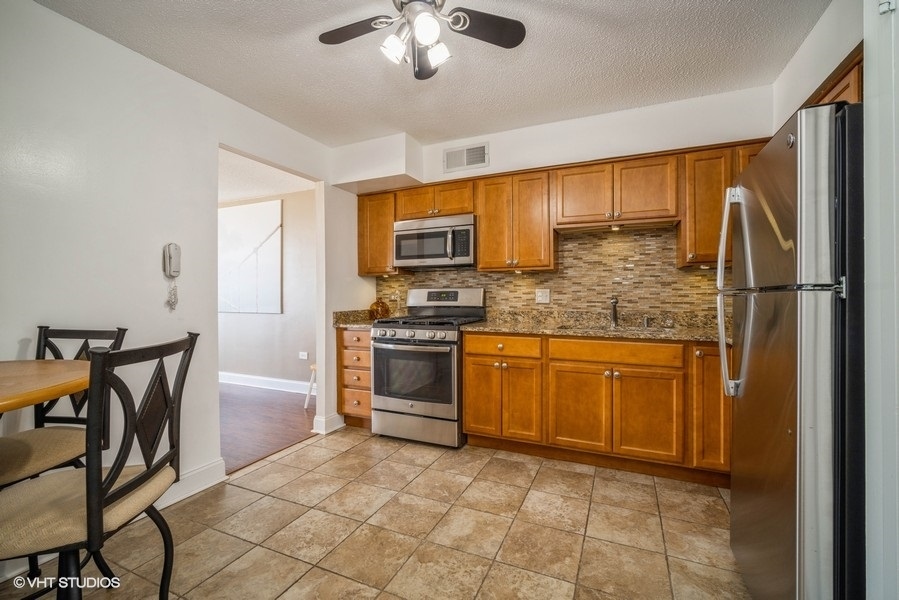 8801 West Golf Road, Unit 10E Niles, IL 60714 - Photo 12 of 21 a kitchen with stainless steel appliances granite countertop a stove top oven a sink and a refrigerator