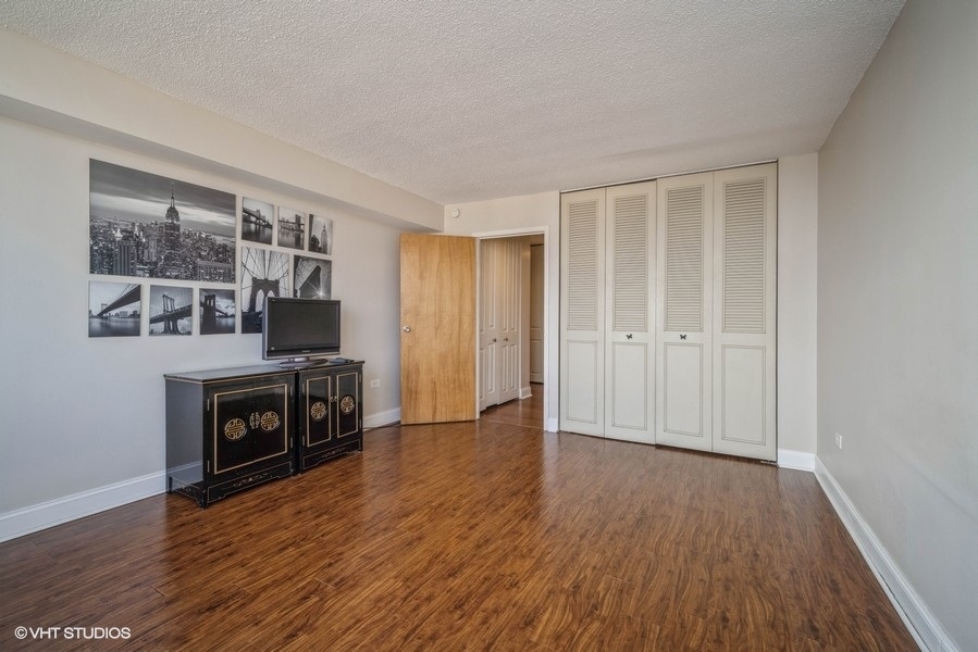 8801 West Golf Road, Unit 10E Niles, IL 60714 - Photo 16 of 21 a view of an empty room with wooden floor and a window