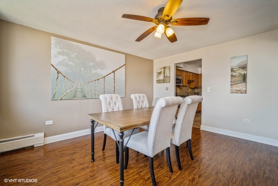 8801 West Golf Road, Unit 10E Niles, IL 60714 - Photo 7 of 21 a view of a dining room with furniture and wooden floor