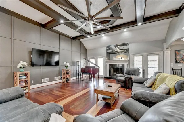 a dining room with wooden floor a chandelier a wooden table and chairs