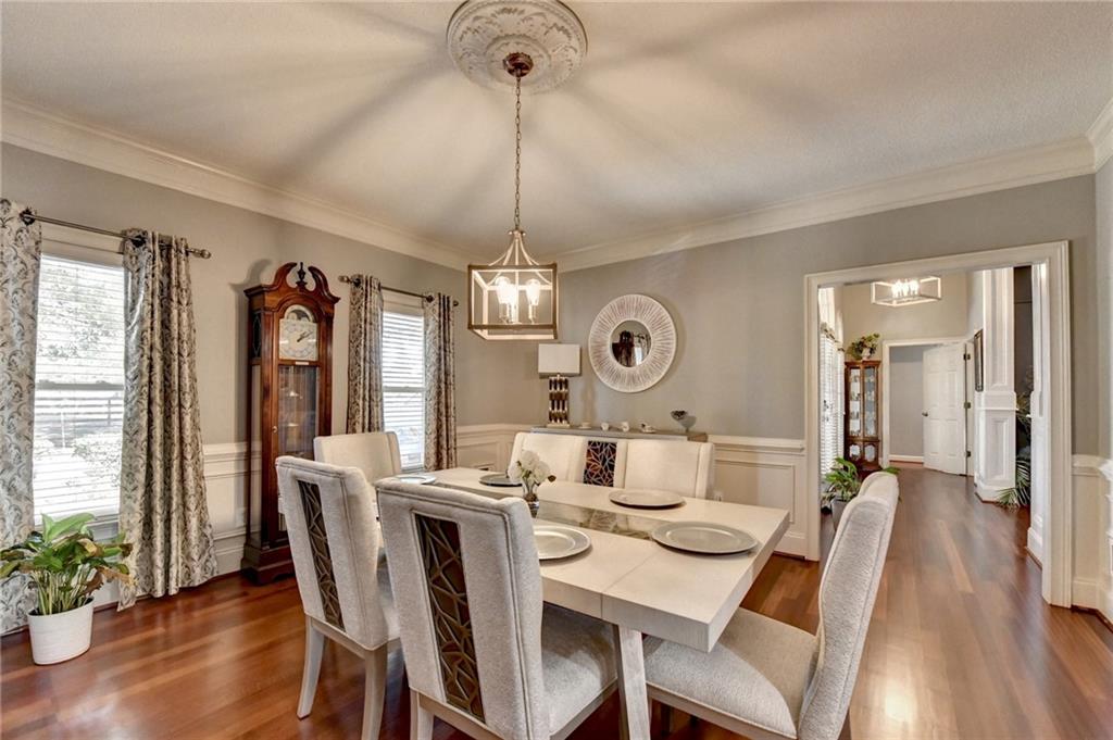 4420 Benefield Road Braselton, GA 30517 - Photo 15 of 34 a dining room with wooden floor a chandelier a wooden table and chairs