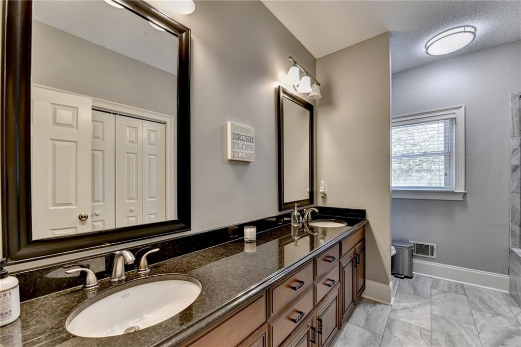 4420 Benefield Road Braselton, GA 30517 - Photo 22 of 34 a bathroom with double sink and a mirror