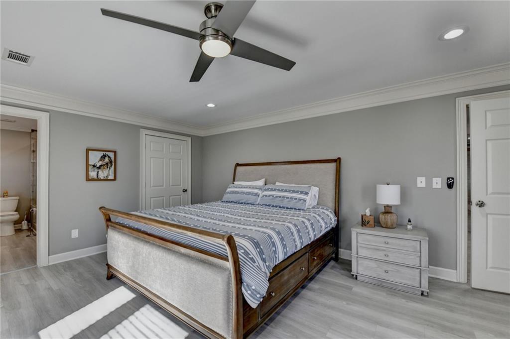 4420 Benefield Road Braselton, GA 30517 - Photo 26 of 34 a bedroom with a bed and a chandelier
