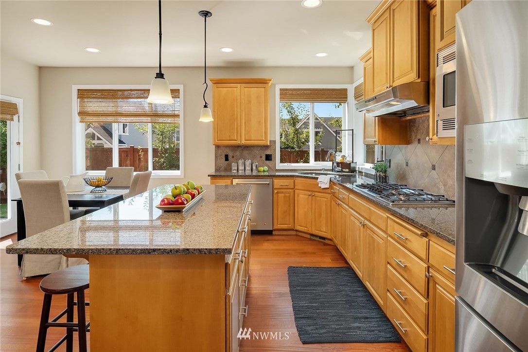 3930 215th Street Southeast Bothell, WA 98021 - Photo 11 of 35 a kitchen with stainless steel appliances granite countertop a sink a stove and a refrigerator