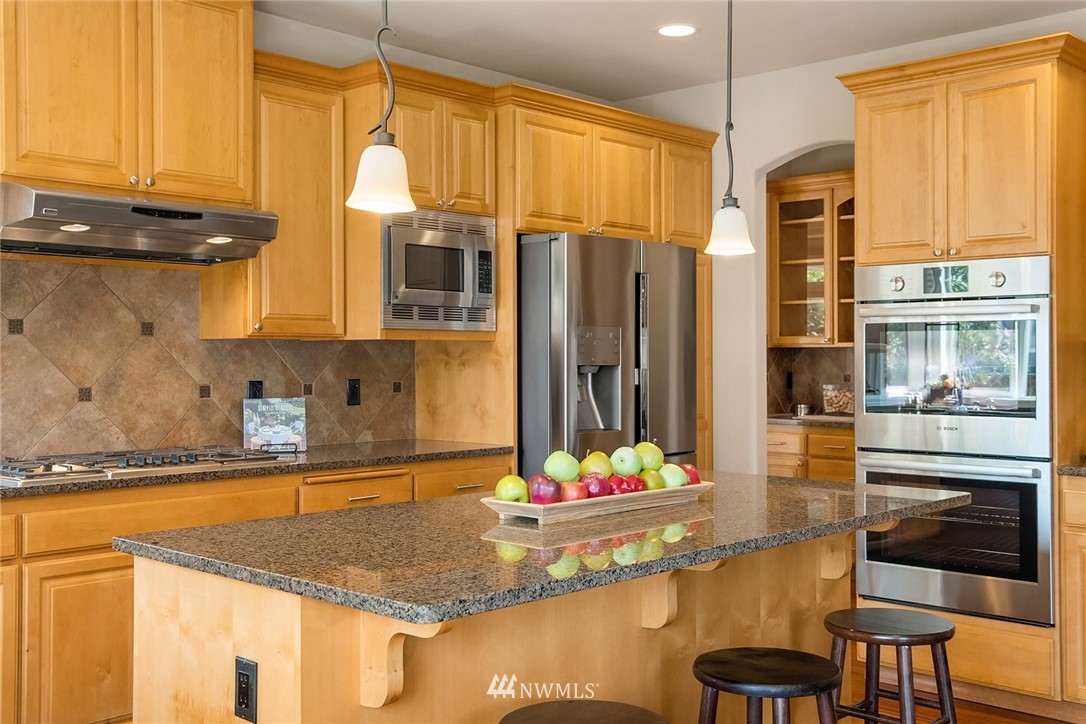3930 215th Street Southeast Bothell, WA 98021 - Photo 14 of 35 a kitchen with granite countertop sink and cabinets