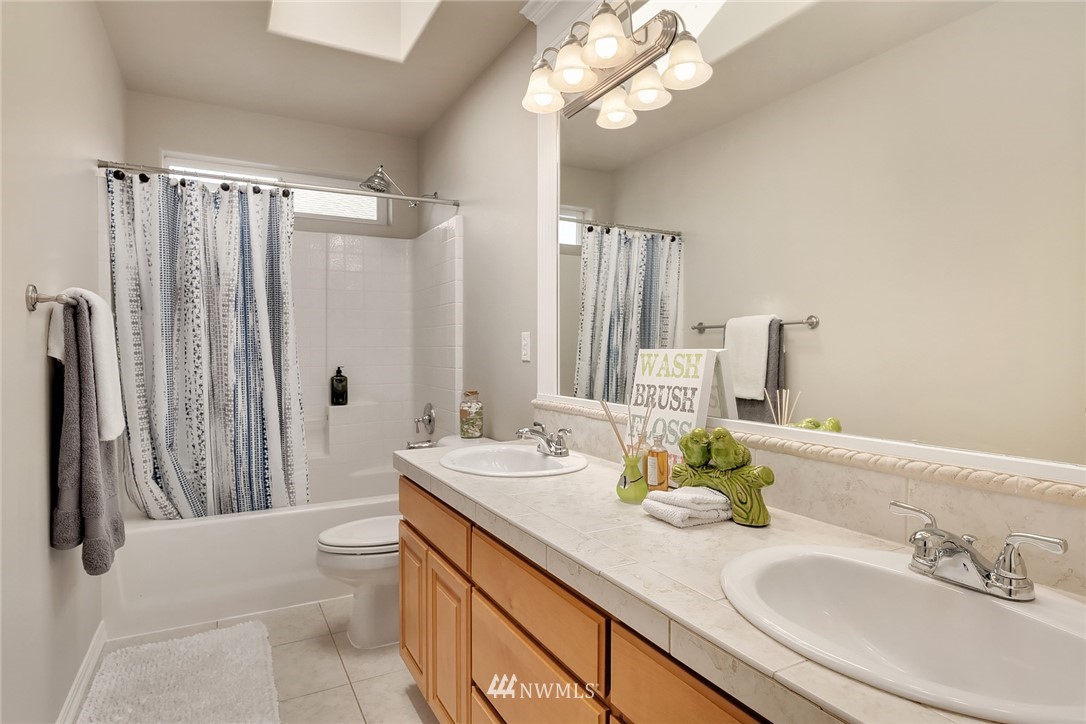 3930 215th Street Southeast Bothell, WA 98021 - Photo 30 of 35 a bathroom with a granite countertop sink a toilet and a mirror