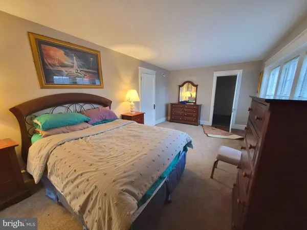 a bed sitting in a spacious bedroom next to a window