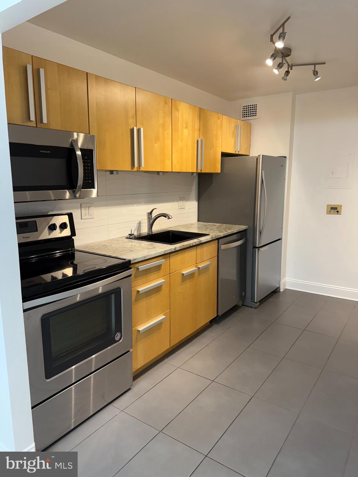 2059 Huntington Avenue, Unit 111 Alexandria, VA 22303 - Photo 12 of 34 a kitchen with stainless steel appliances granite countertop a stove a sink and a refrigerator