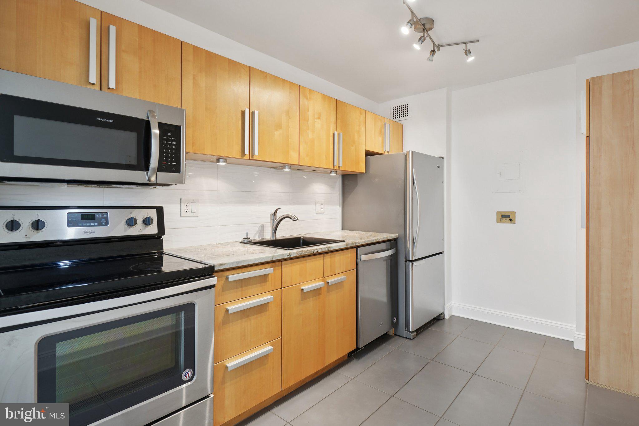 2059 Huntington Avenue, Unit 111 Alexandria, VA 22303 - Photo 14 of 34 a kitchen with stainless steel appliances granite countertop a stove microwave refrigerator and cabinets