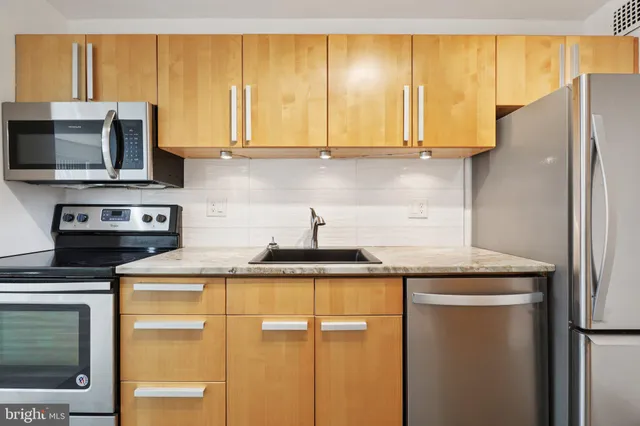 a kitchen with stainless steel appliances granite countertop a refrigerator and a sink