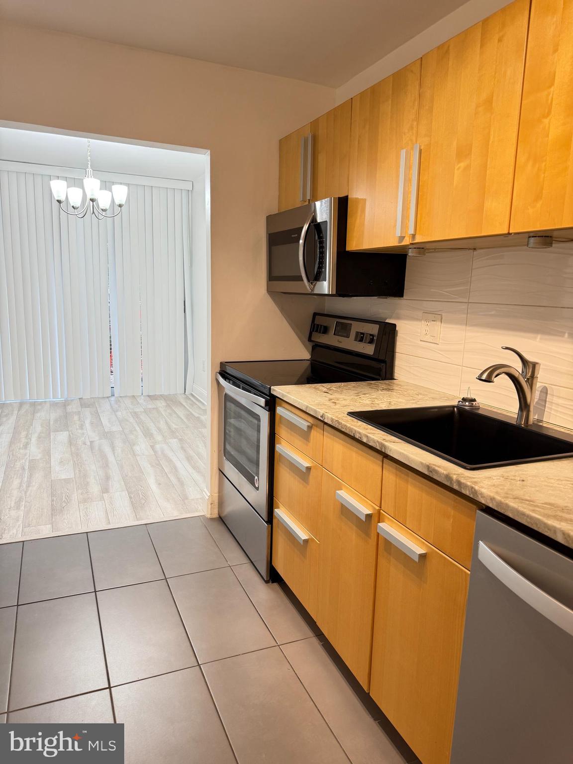 2059 Huntington Avenue, Unit 111 Alexandria, VA 22303 - Photo 18 of 34 a kitchen with stainless steel appliances a sink a stove top oven a counter space and cabinets