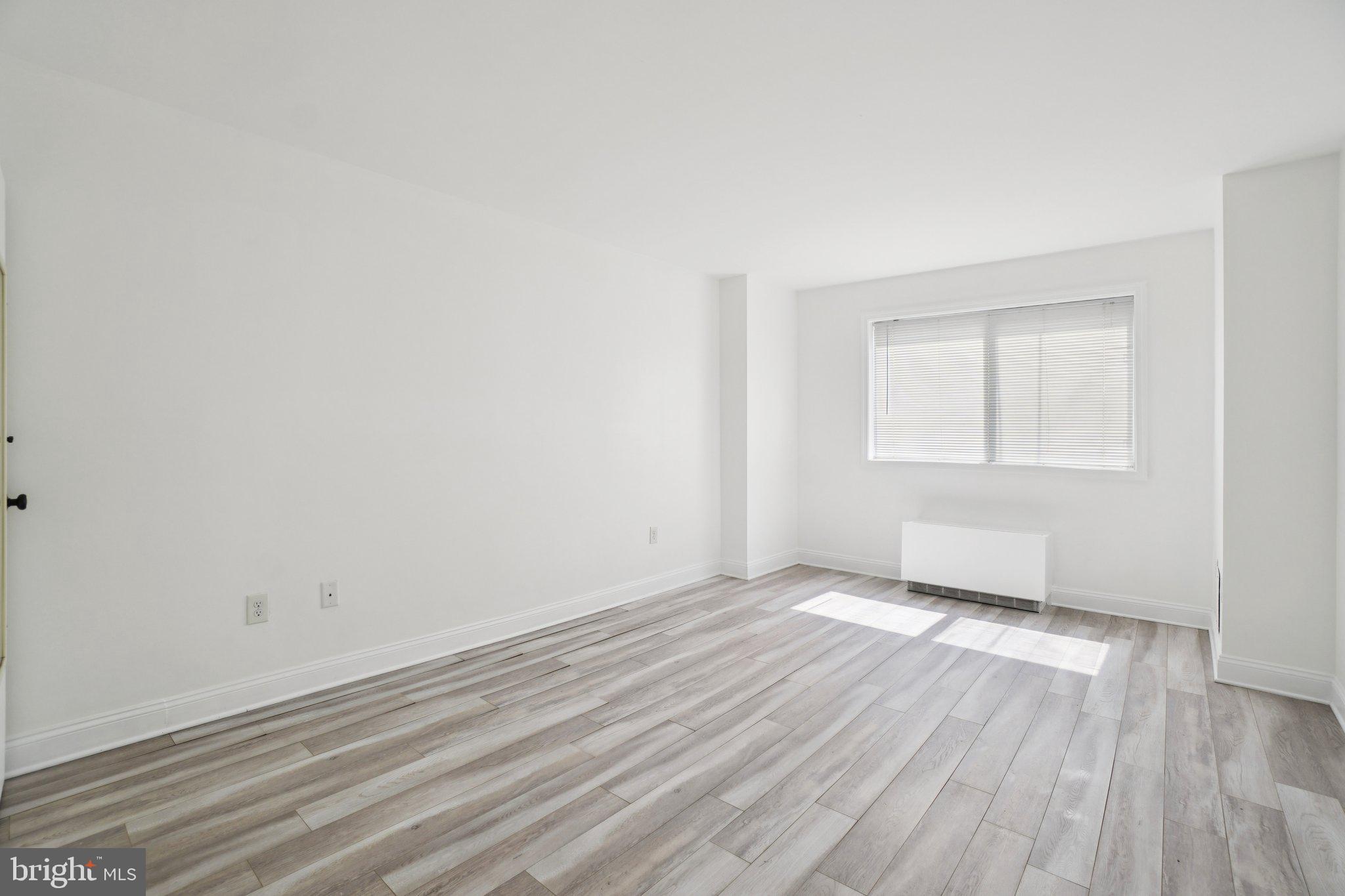 2059 Huntington Avenue, Unit 111 Alexandria, VA 22303 - Photo 20 of 34 an empty room with wooden floor and windows