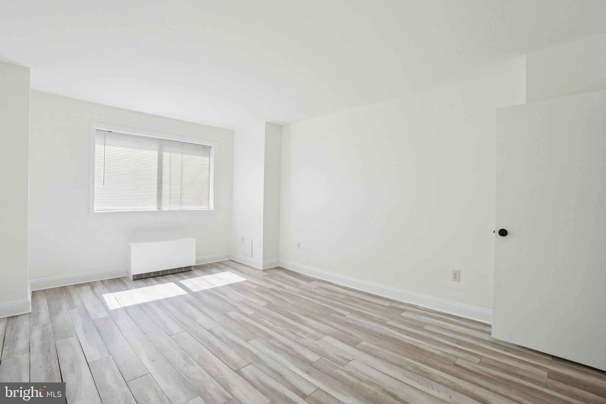 2059 Huntington Avenue, Unit 111 Alexandria, VA 22303 - Photo 21 of 34 an empty room with wooden floor and windows