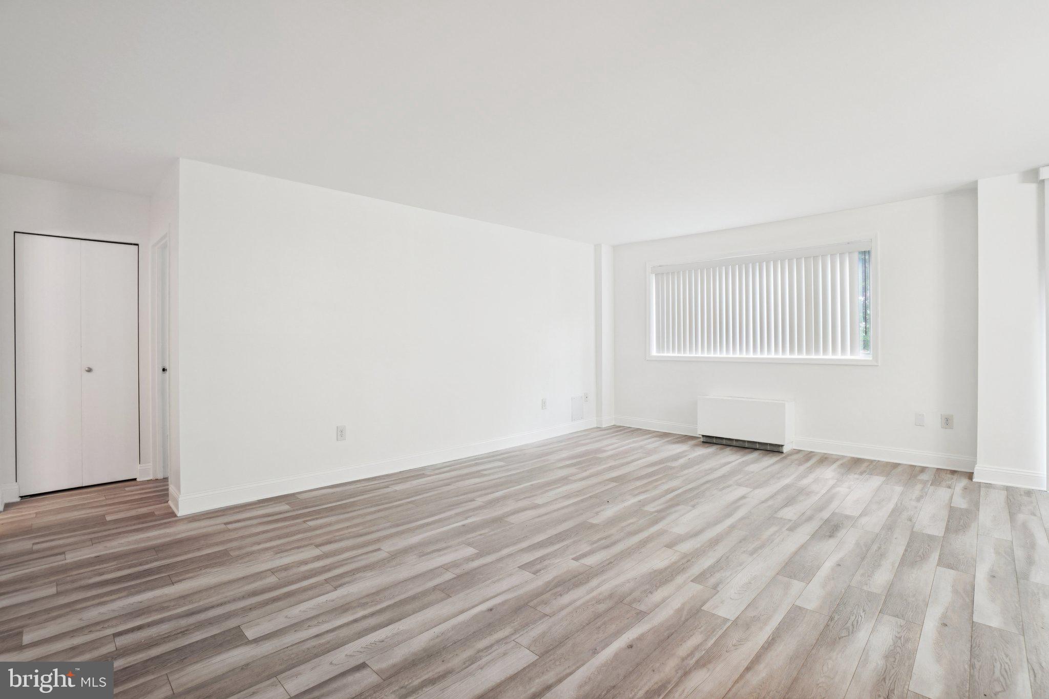 2059 Huntington Avenue, Unit 111 Alexandria, VA 22303 - Photo 5 of 34 a view of an empty room with wooden floor and a window