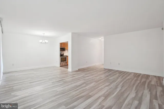 a view of empty room with wooden floor and window