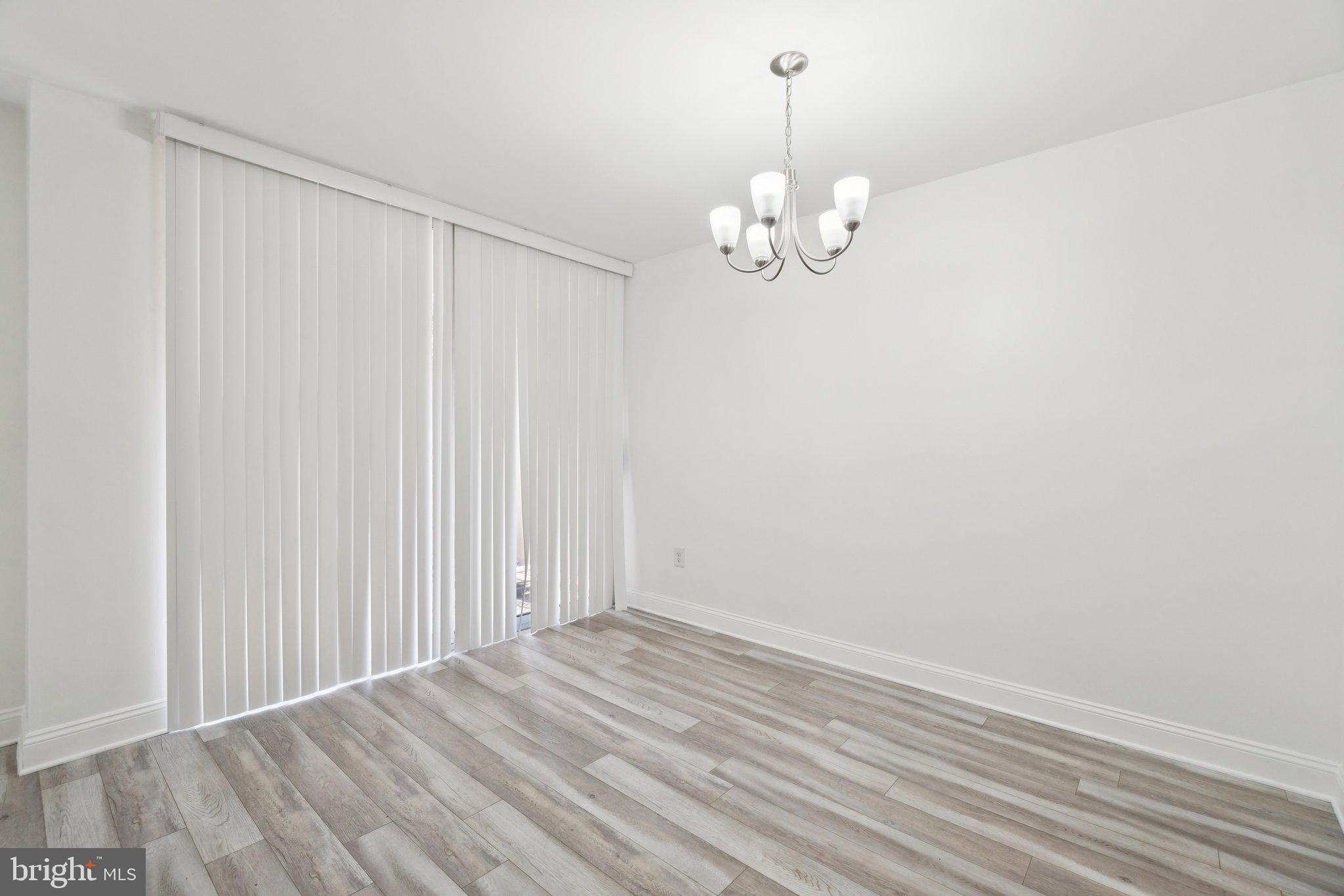 2059 Huntington Avenue, Unit 111 Alexandria, VA 22303 - Photo 10 of 34 a view of a chandelier fan and wooden floor