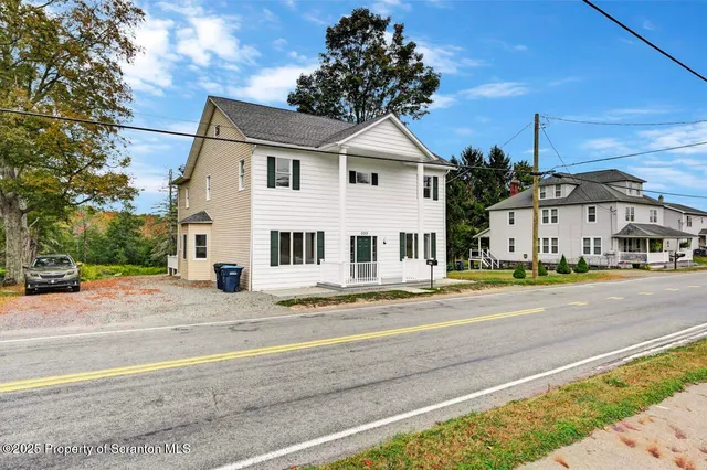 a front view of a house with a yard and trees