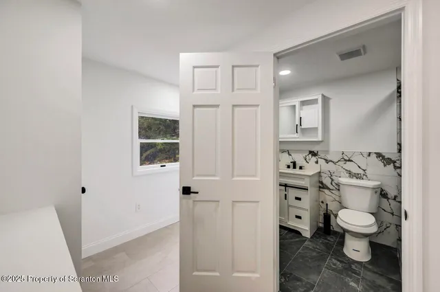 a bathroom with a sink a toilet and a mirror