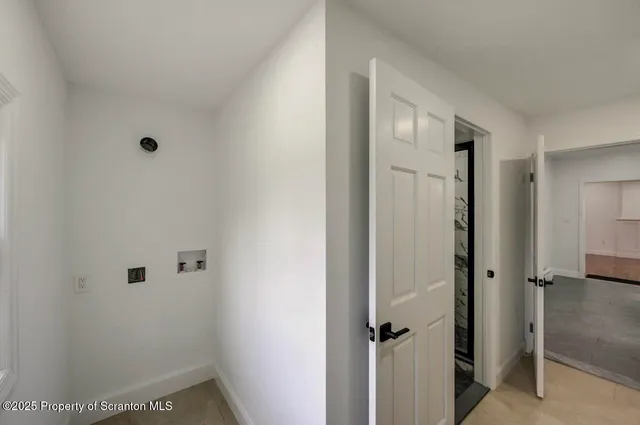a view of hallway with window and wooden floor