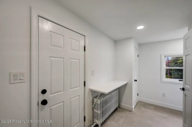 a view of hallway with stairs and wooden floor