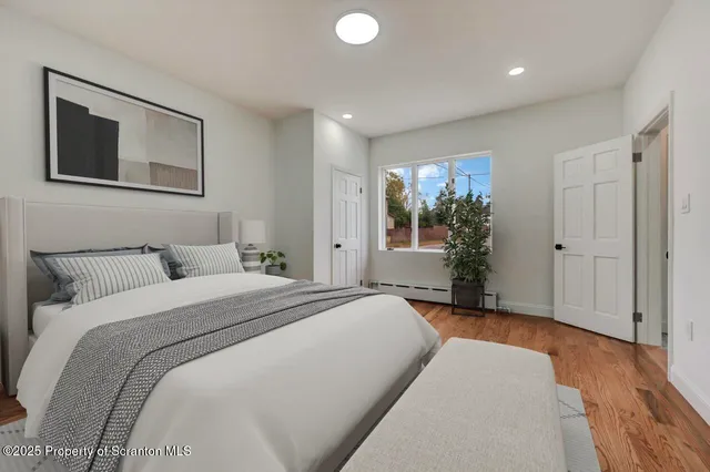 an empty room with wooden floor and bathroom