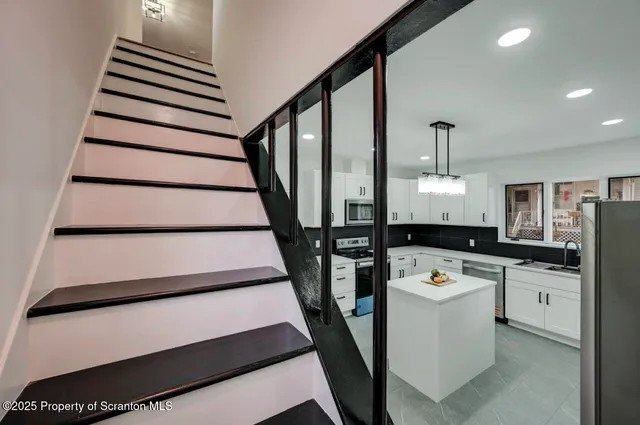 a view of an empty room with wooden floor and closet