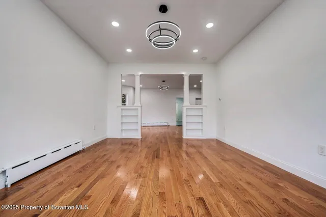 a view of an empty room with a window and fireplace