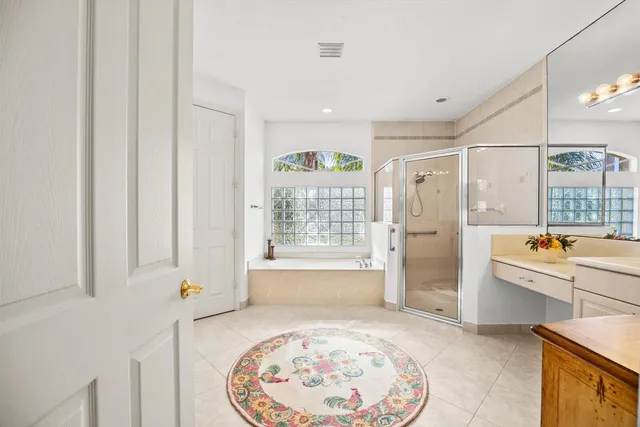 a spacious bathroom with a tub sink and mirror
